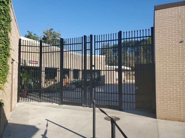 A Brick Building Is Behind A Metal Gate – Mishawaka IN - Milestone Fence