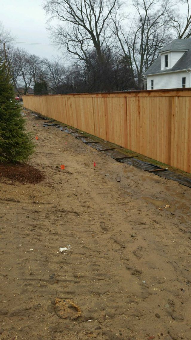 A Long Wooden Fence Surrounds A Dirt Field In Front Of A House – Mishawaka IN - Milestone Fence