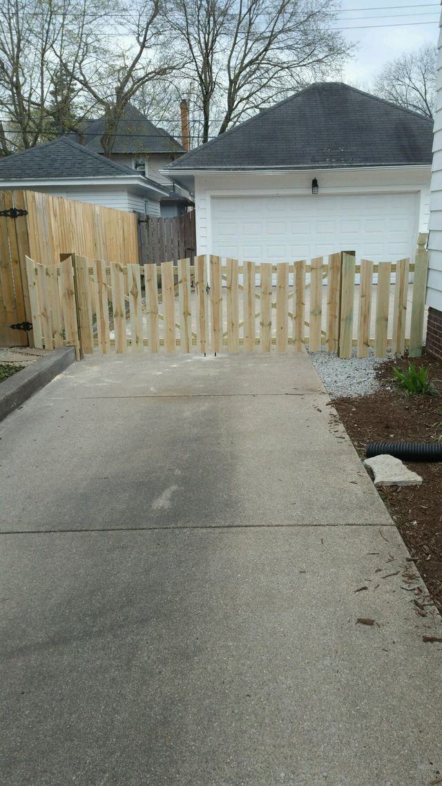 A Wooden Fence Surrounds A Driveway In Front Of A House – Mishawaka IN - Milestone Fence