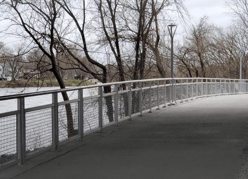 A Bridge Over A River With Trees In The Background – Mishawaka IN - Milestone Fence