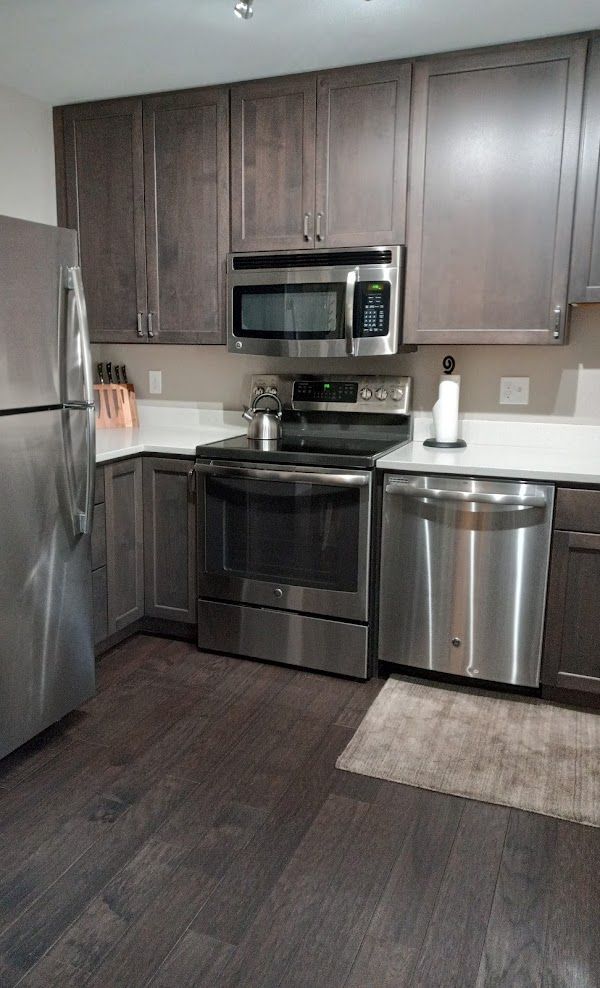 A kitchen with stainless steel appliances and wooden cabinets.