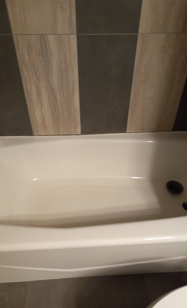 A white bathtub in a bathroom next to a toilet.
