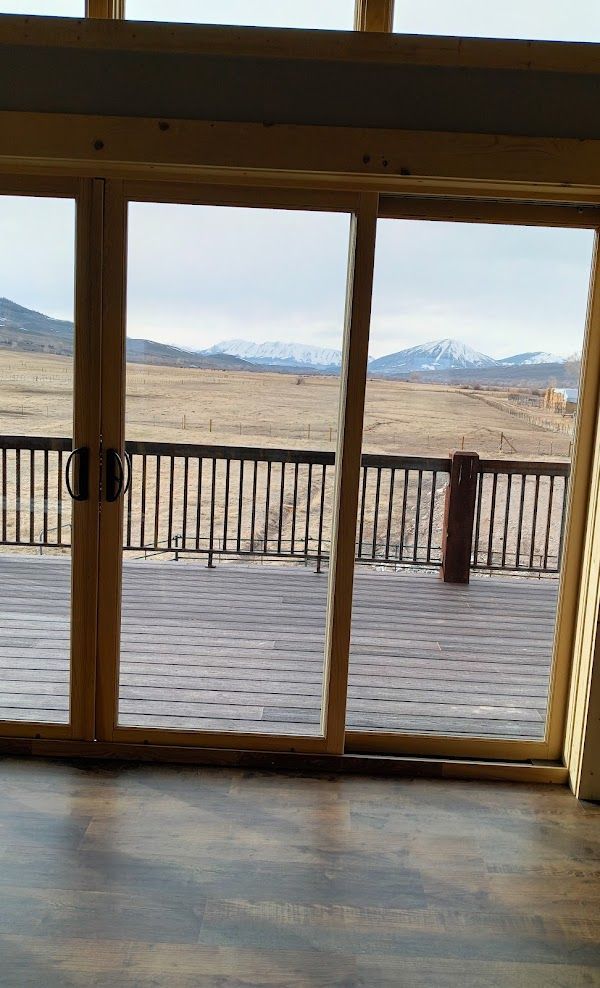 There is a view of a deck through the sliding glass doors.