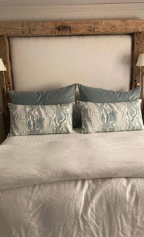A bed with a wooden headboard and pillows on it.