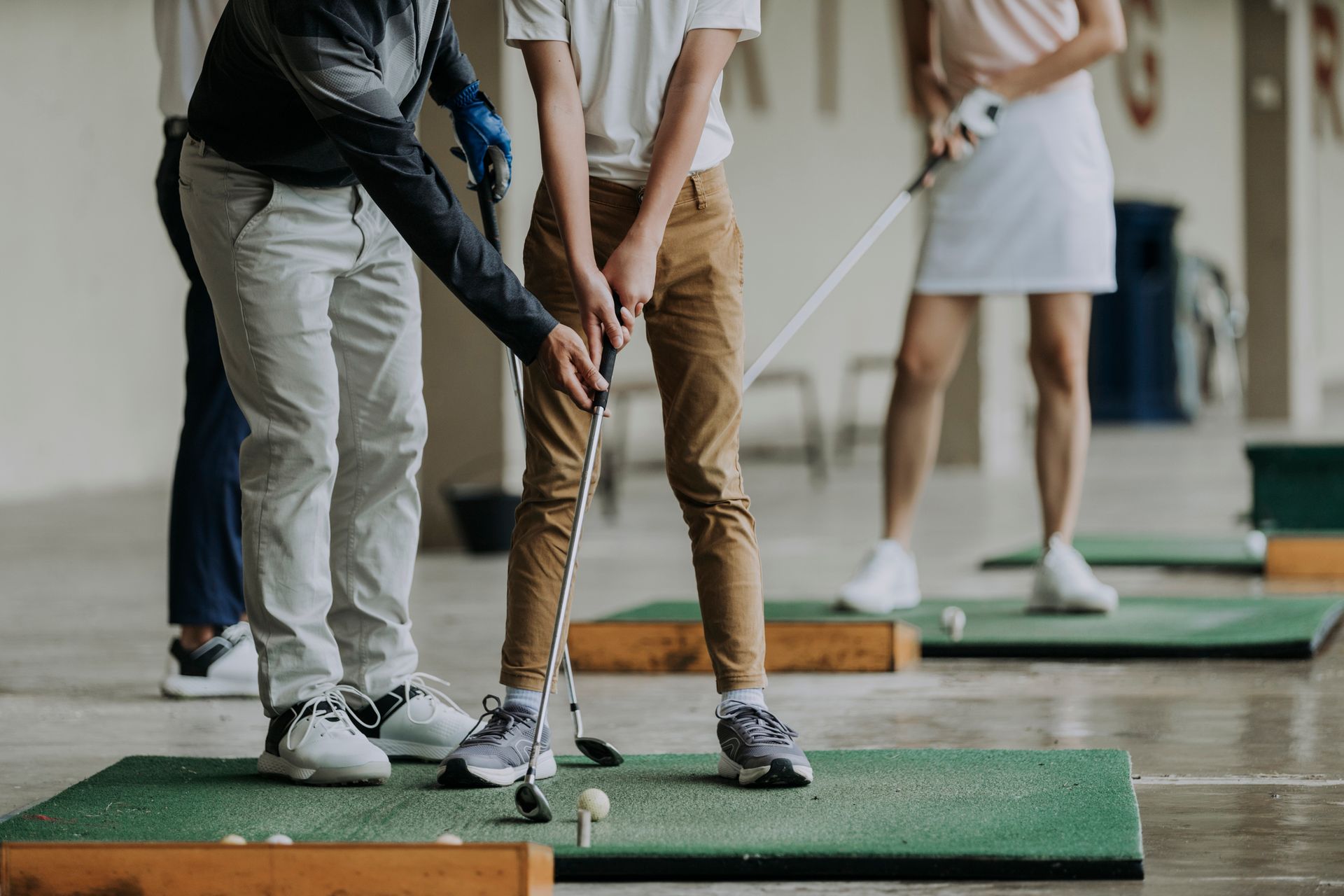 A group of people are practicing golf on a driving range.