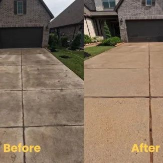 Person pressure washing gray vinyl siding with a hose nozzle, spraying a white stream of water