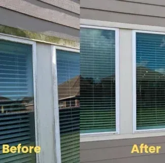 Power washer spraying a white house window and siding