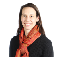 A woman wearing a scarf around her neck is smiling for the camera