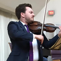 A man in a suit and tie is playing a violin