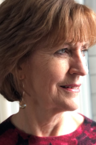 A close up of a woman 's face with a red shirt on