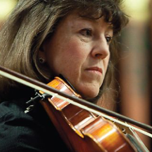 A woman is playing a violin with a bow.