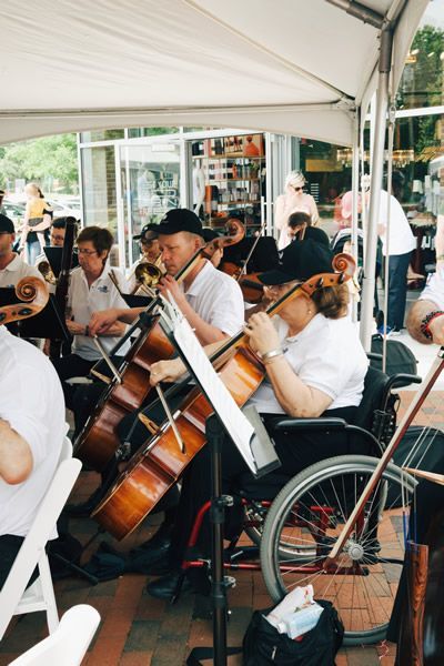 A woman in a wheelchair is playing cello in an orchestra