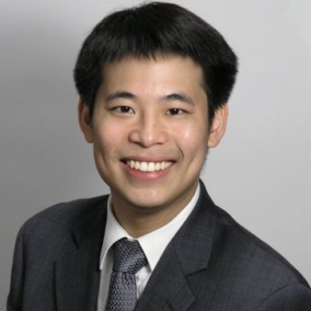 A man in a suit and tie is smiling for the camera