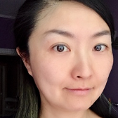 A close up of a woman 's face with a purple background.