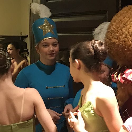 A woman in a blue uniform has a gold star on her hat