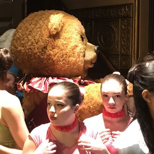 A group of women standing in front of a teddy bear