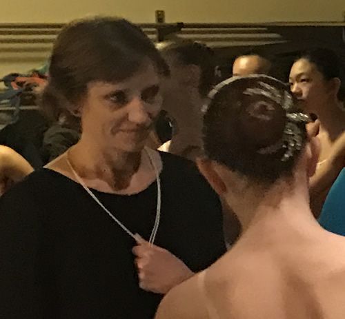 A woman in a bun is talking to another woman