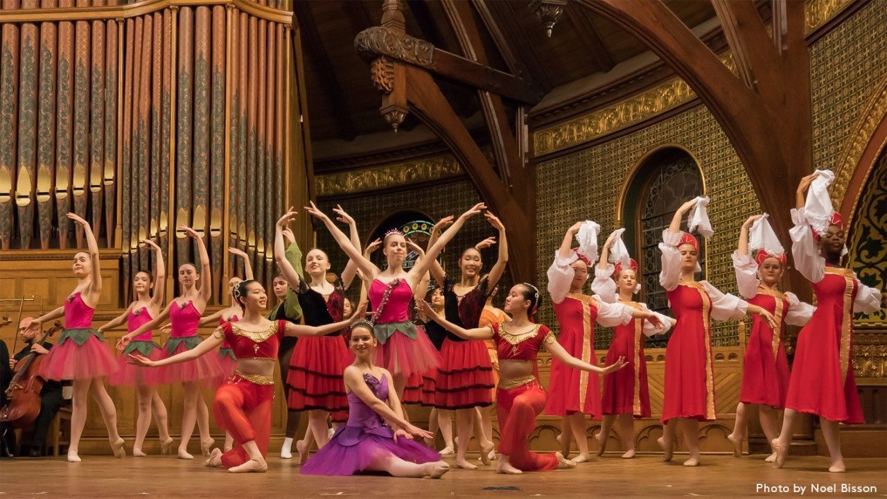 A group of ballerinas are dancing on a stage in a church.