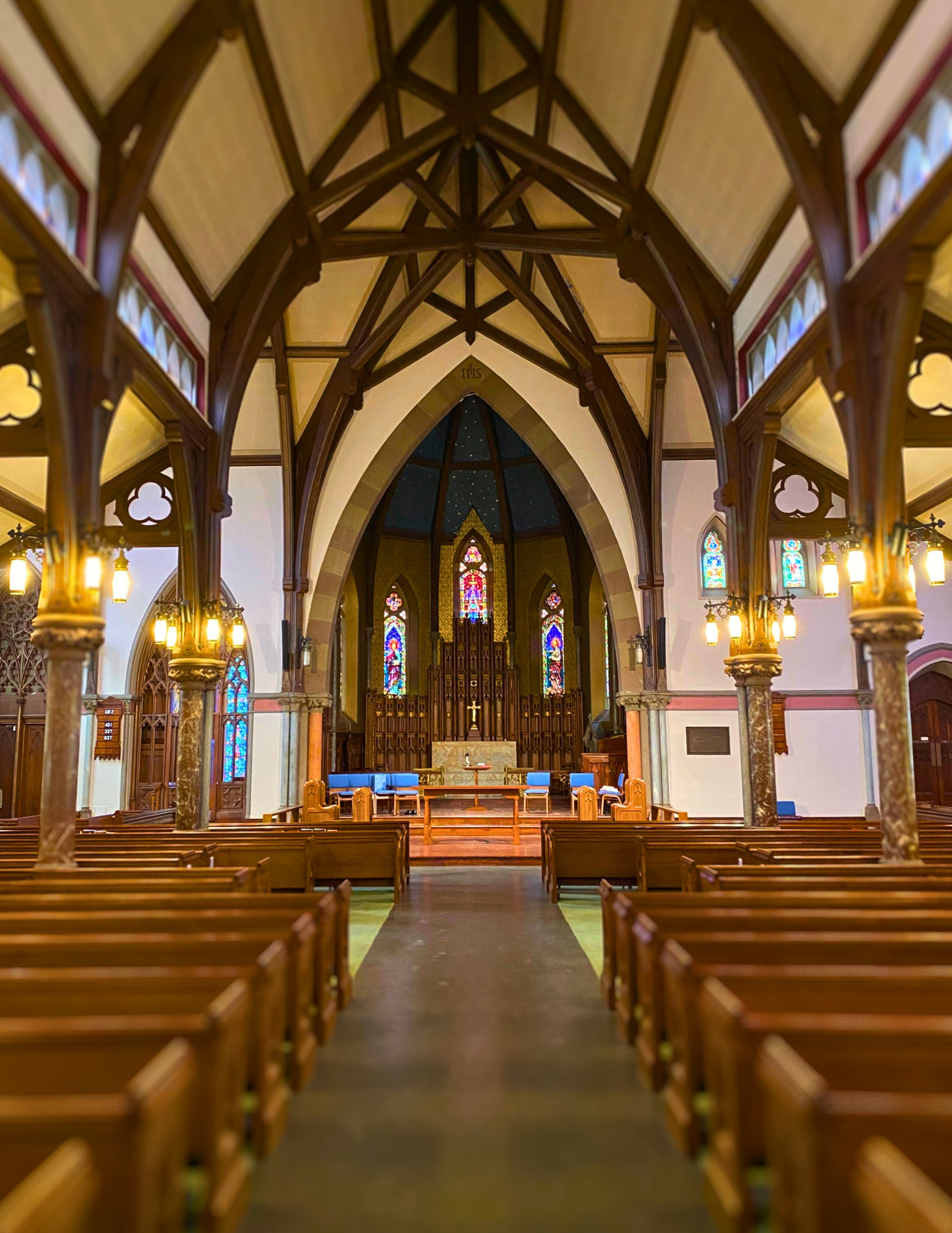 The inside of a church with wooden pews and stained glass windows