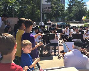 A group of people are standing in front of a band playing instruments.