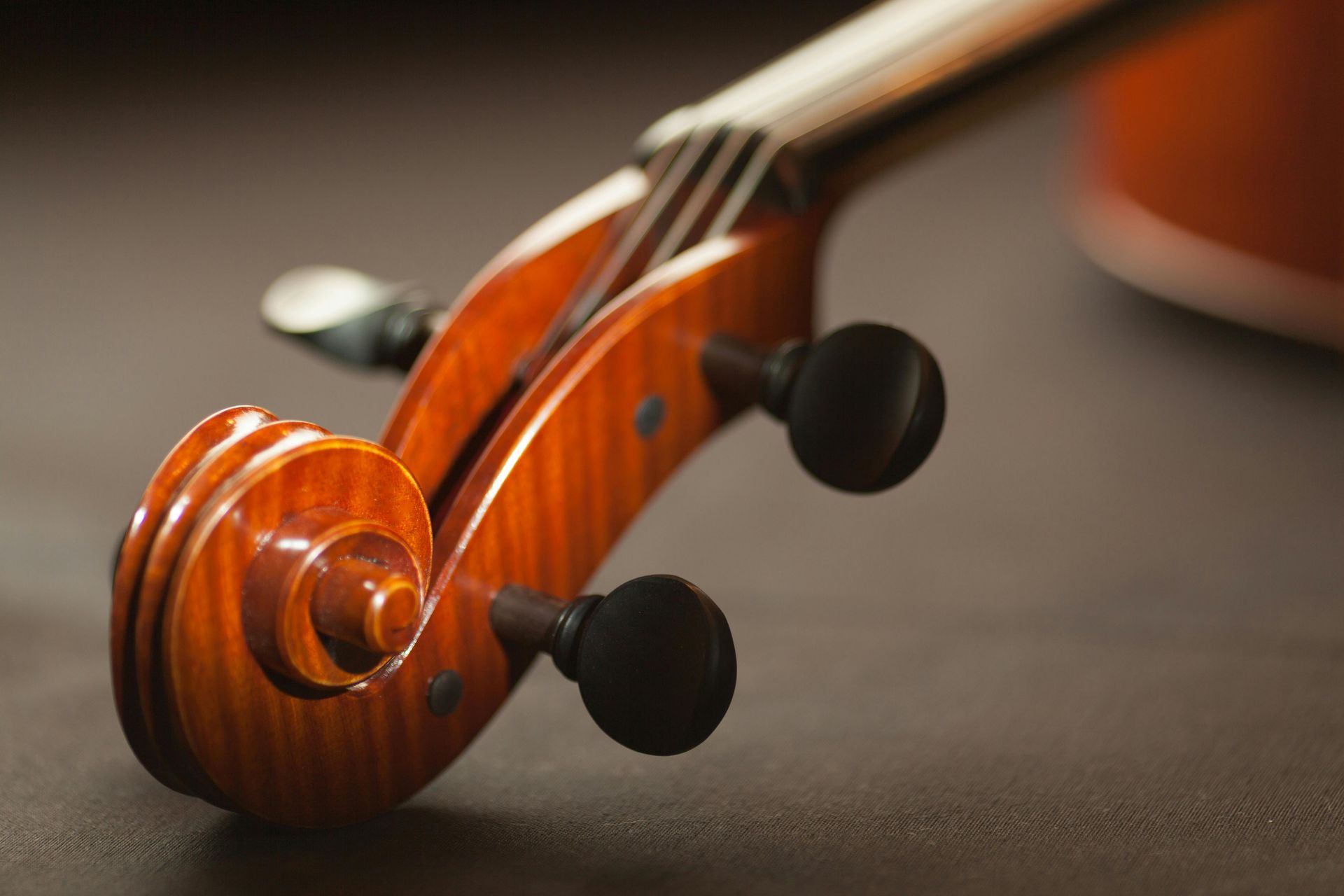 A close up of the headstock of a violin on a table.