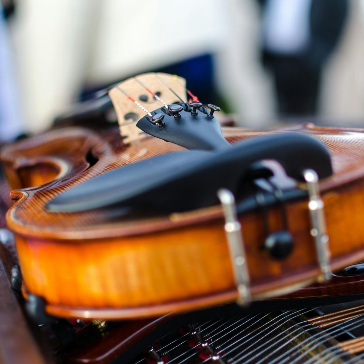 A violin sits on top of a piano keyboard