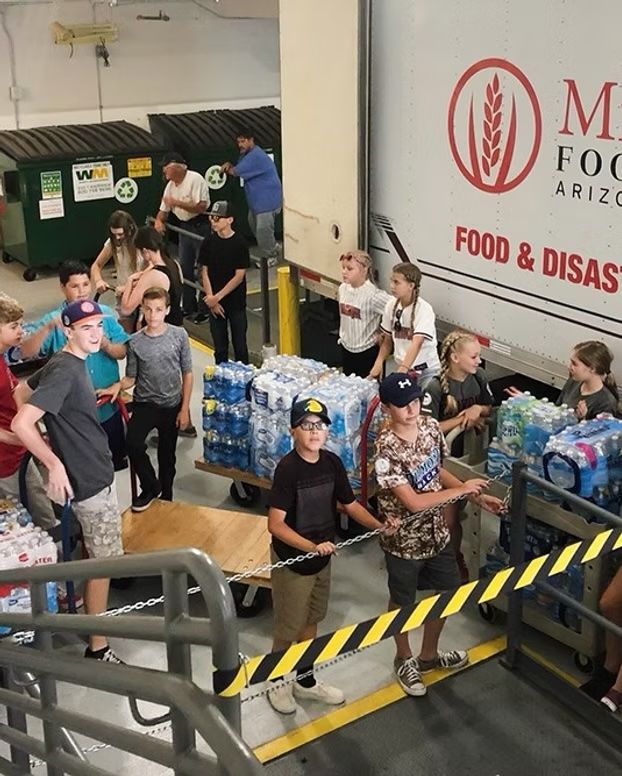 A group of people are standing in front of a food and disas truck