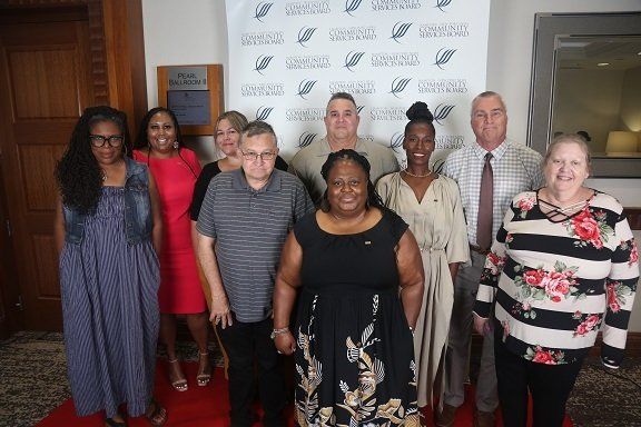 a group of people are posing for a picture on a red carpet .