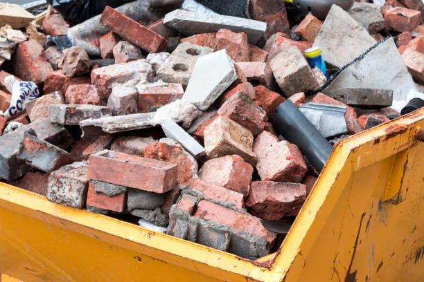 Yellow skip filled with rubble, including bricks and concrete.