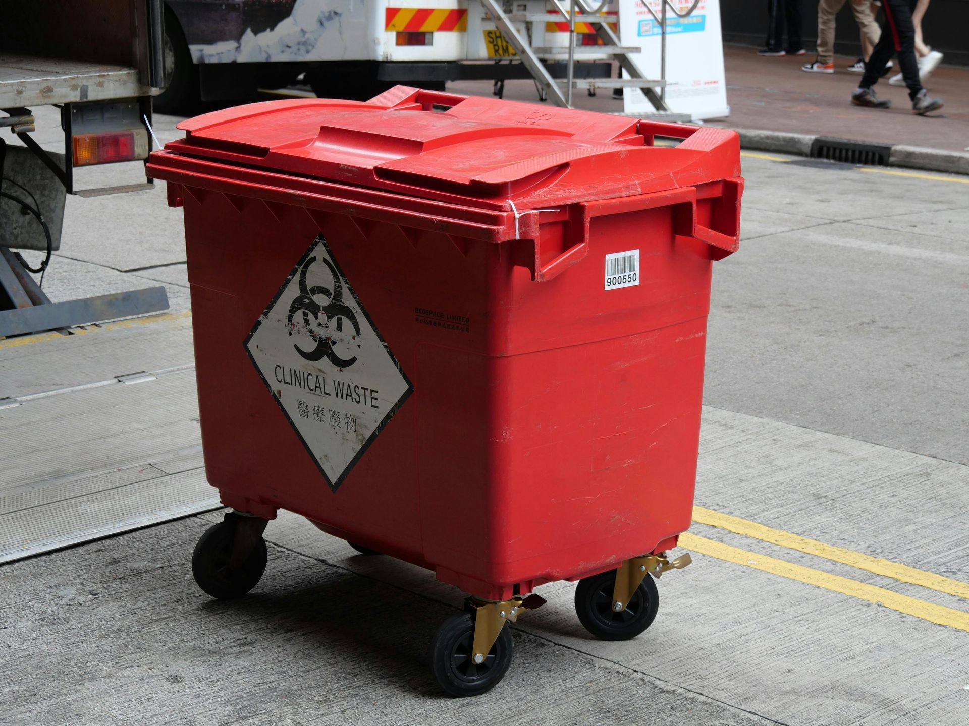Red biohazard waste container on wheels.