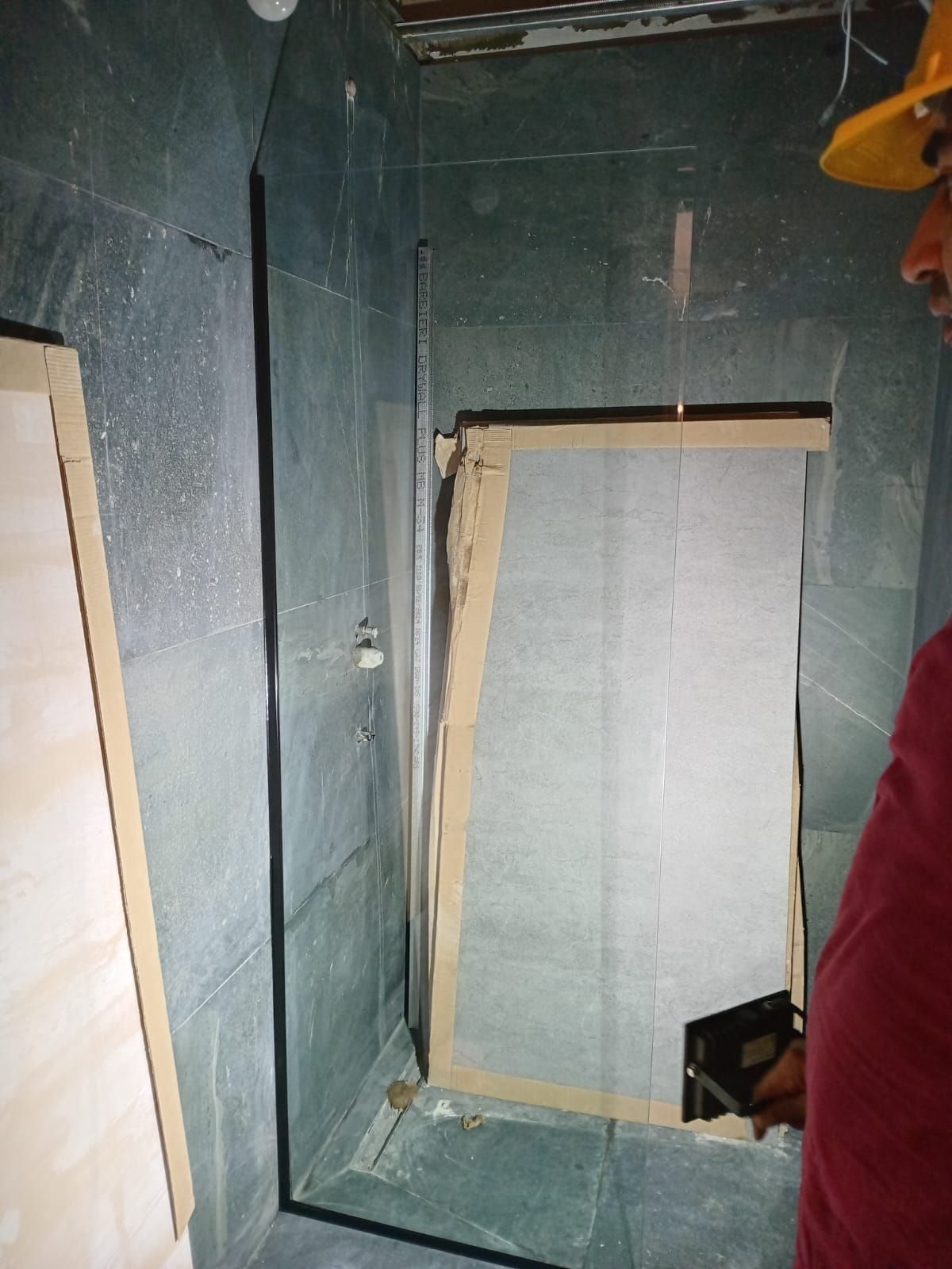 Una persona con casco mira hacia una puerta en una habitación con paredes de color verde oscuro