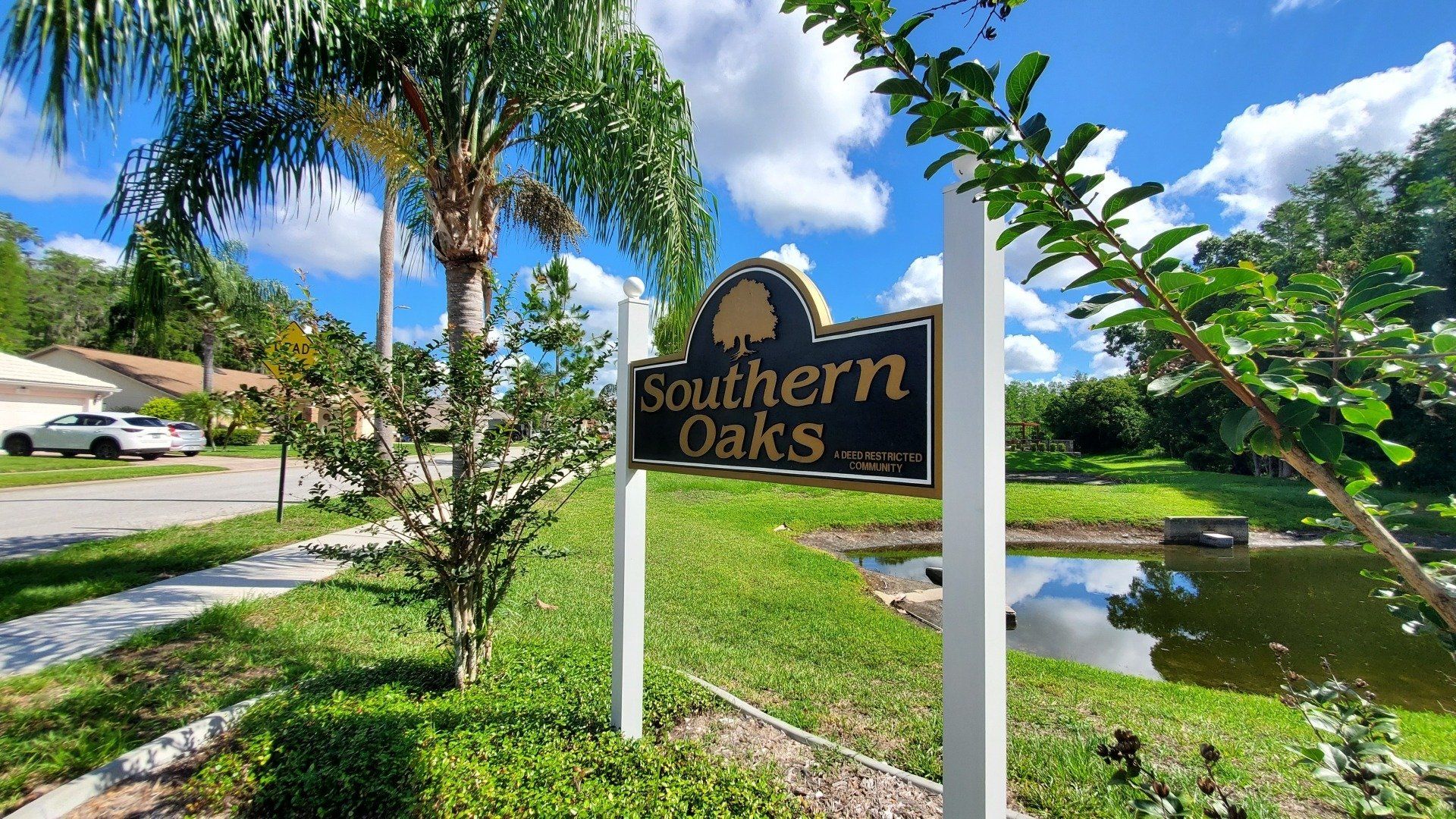 A sign for southern oaks is in front of a house.
