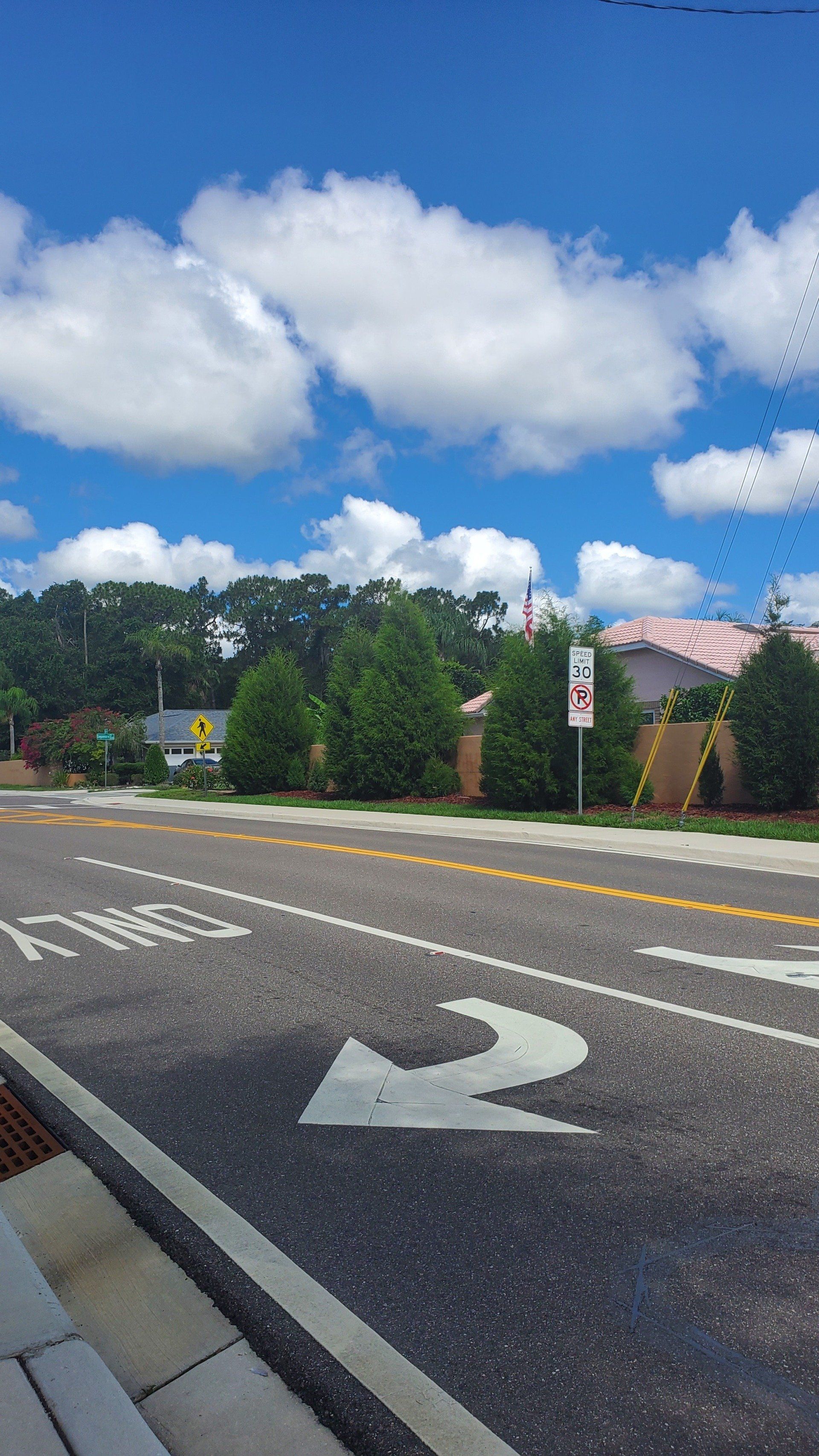 A street with an arrow pointing to the right on a sunny day.