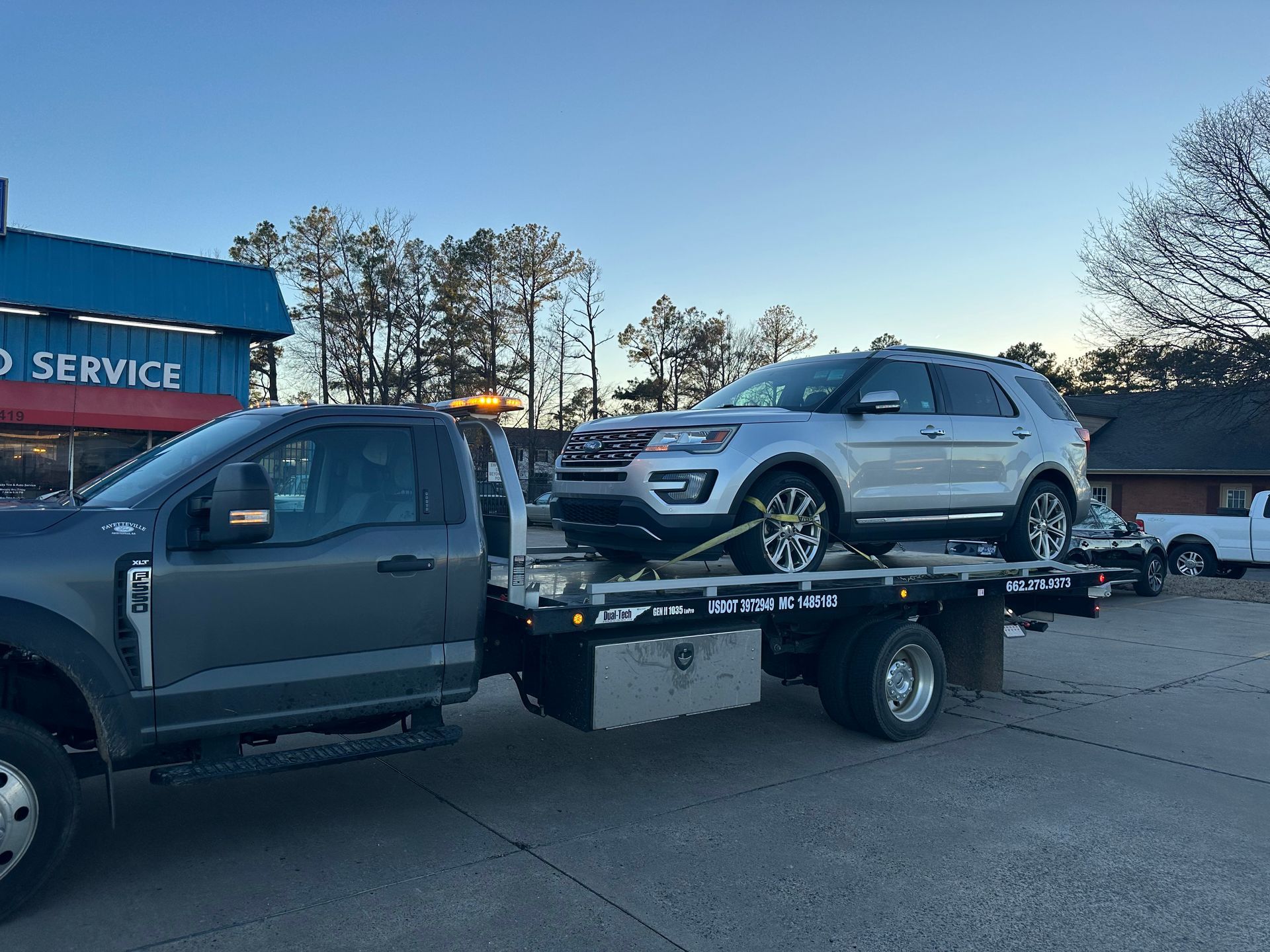 Two cars are being towed by a tow truck.