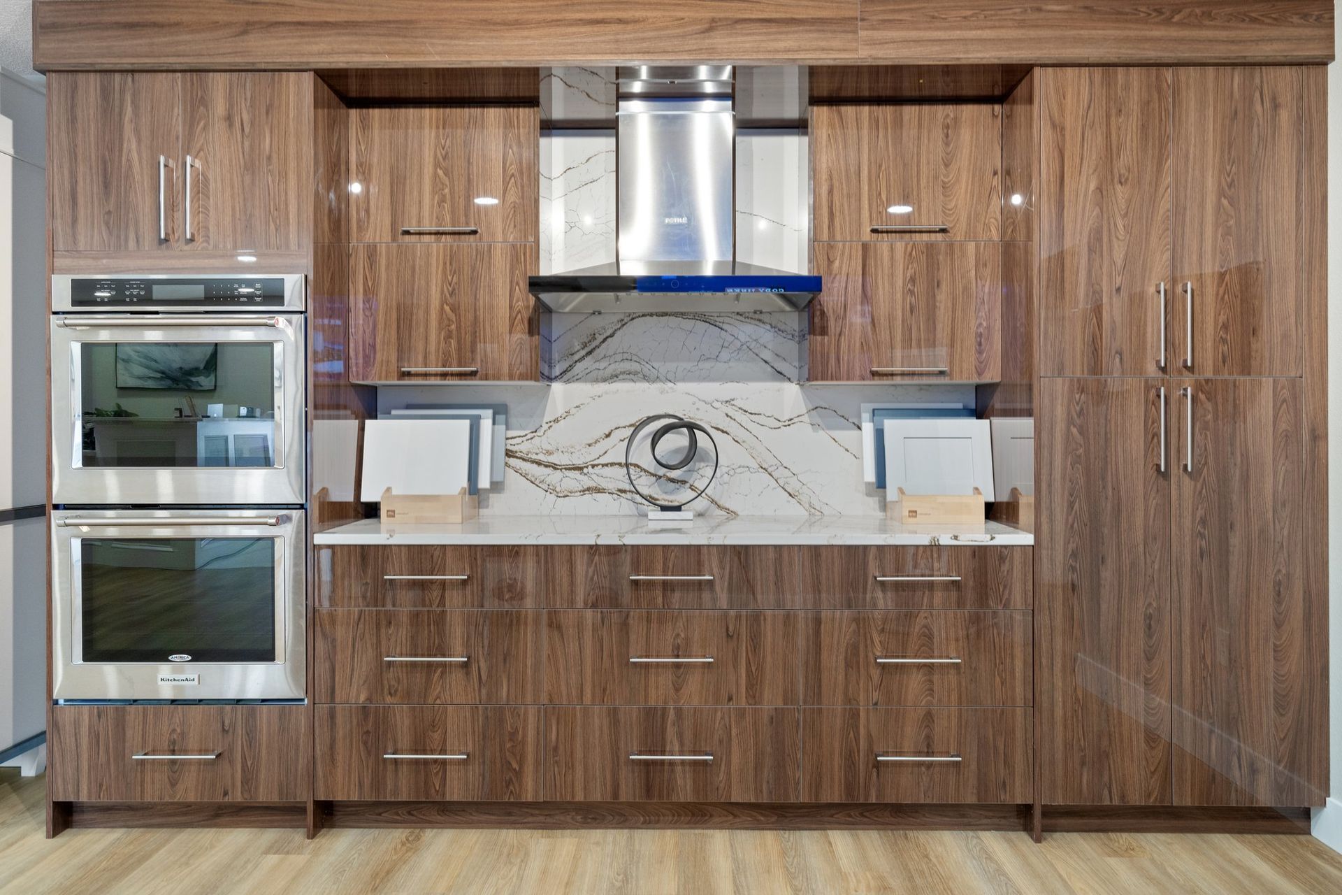 Modern kitchen with brown wood cabinets, stainless steel appliances, and a marble backsplash.