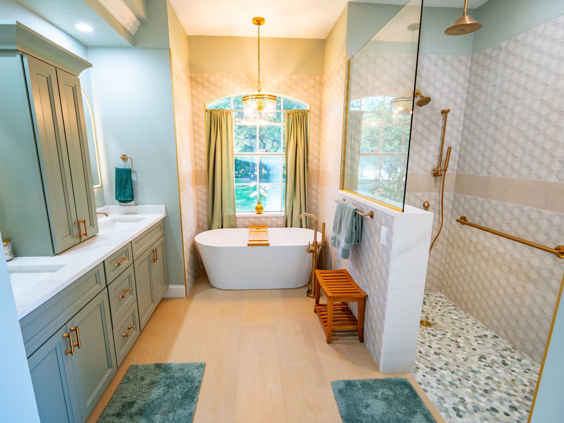 Spacious bathroom with a freestanding tub, glass shower, and green and gold accents.