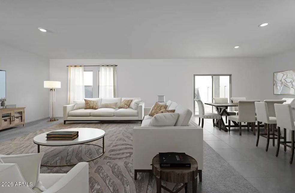A bright, modern open-plan living and dining room with a white sofa, a round coffee table, and a dining table with chairs.
