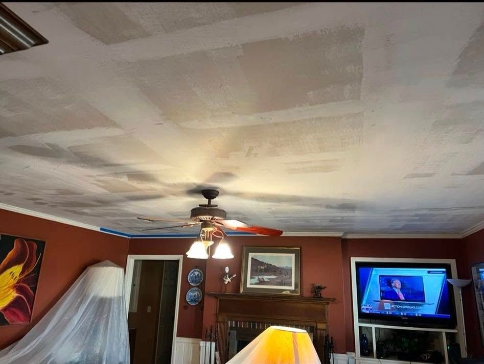 A living room with a ceiling fan and a flat screen tv