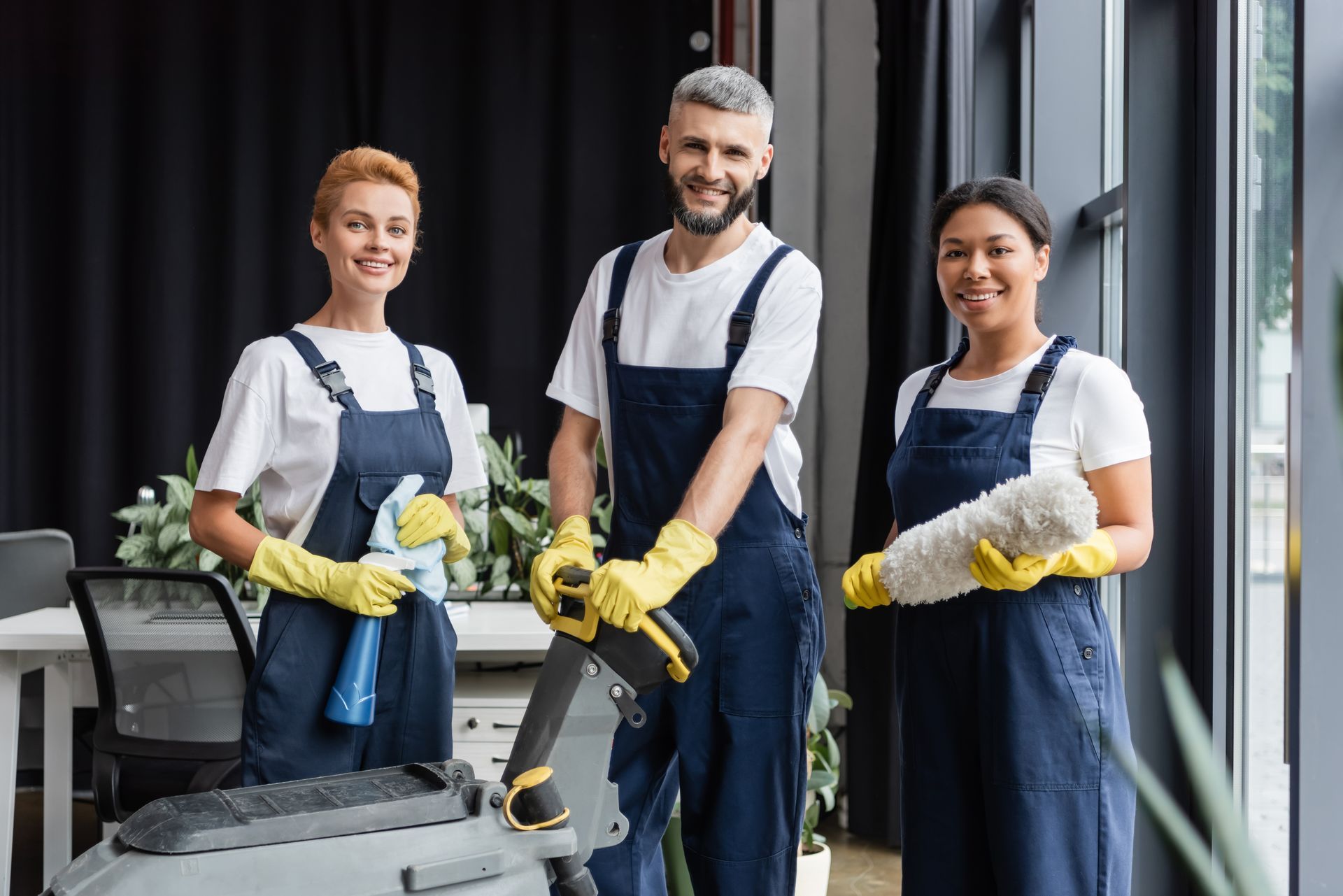 A group of cleaners are standing next to each other in an office.