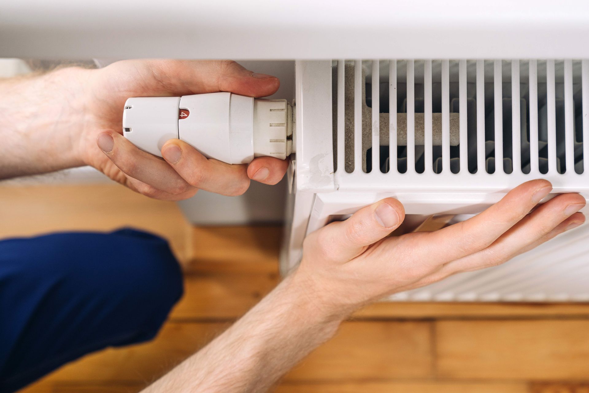 Home heating radiator maintenance with a plumber installing a new component.