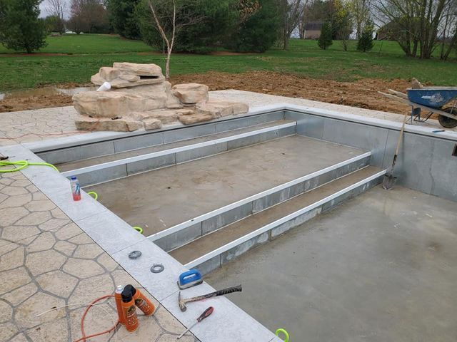 A swimming pool is being built in a backyard.