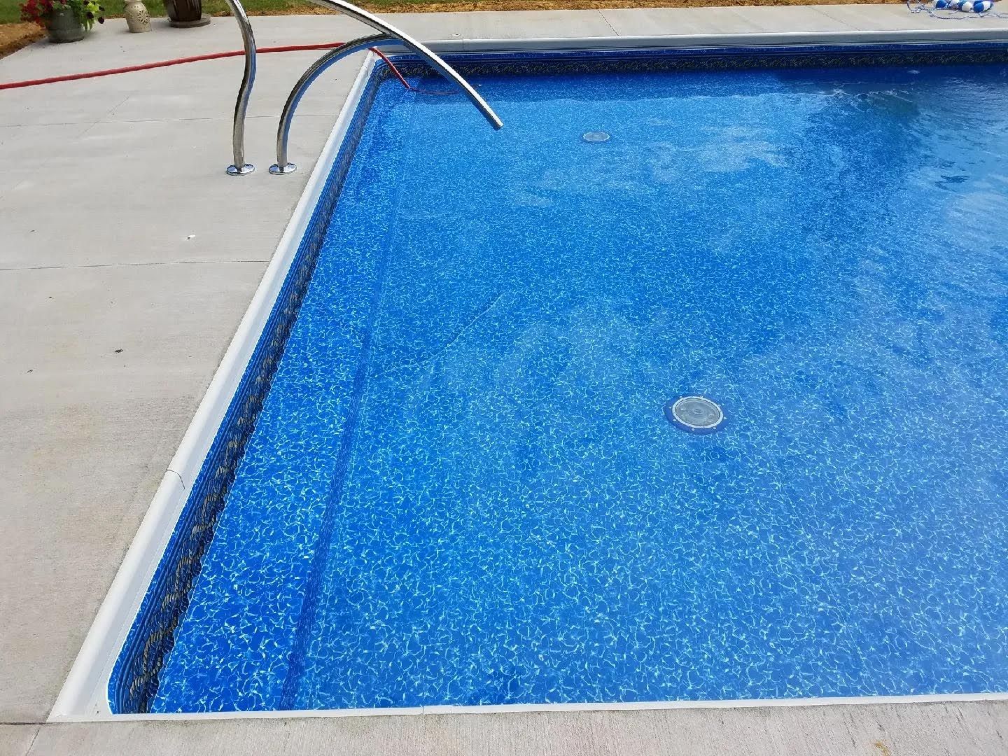 A blue swimming pool with stairs leading to it