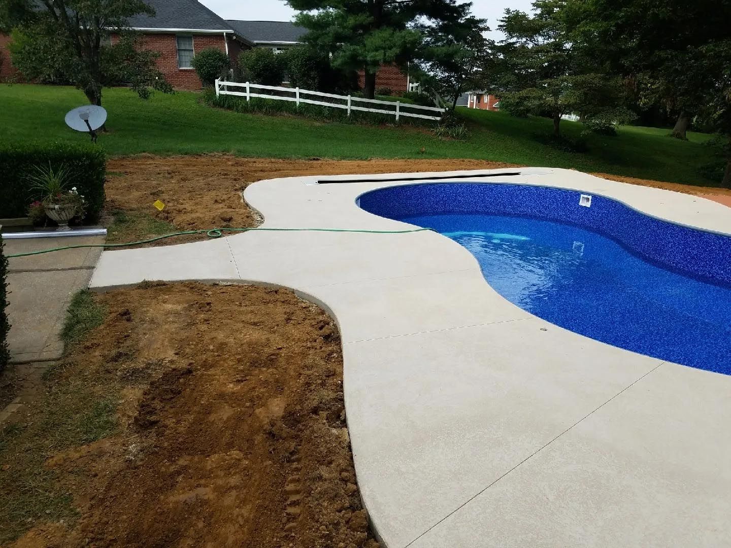 A large swimming pool is surrounded by a concrete walkway