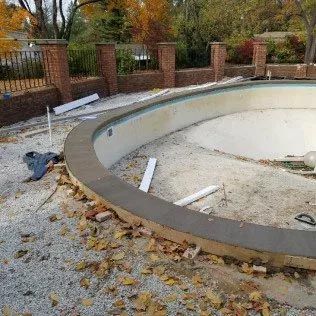 A large swimming pool is being built in a backyard.