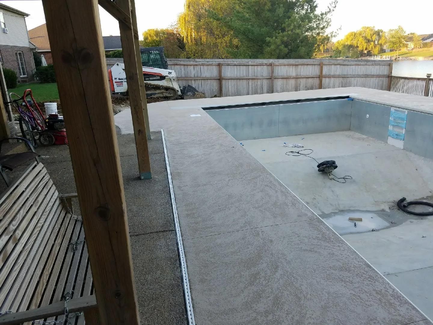 A swimming pool is being built in the backyard of a house