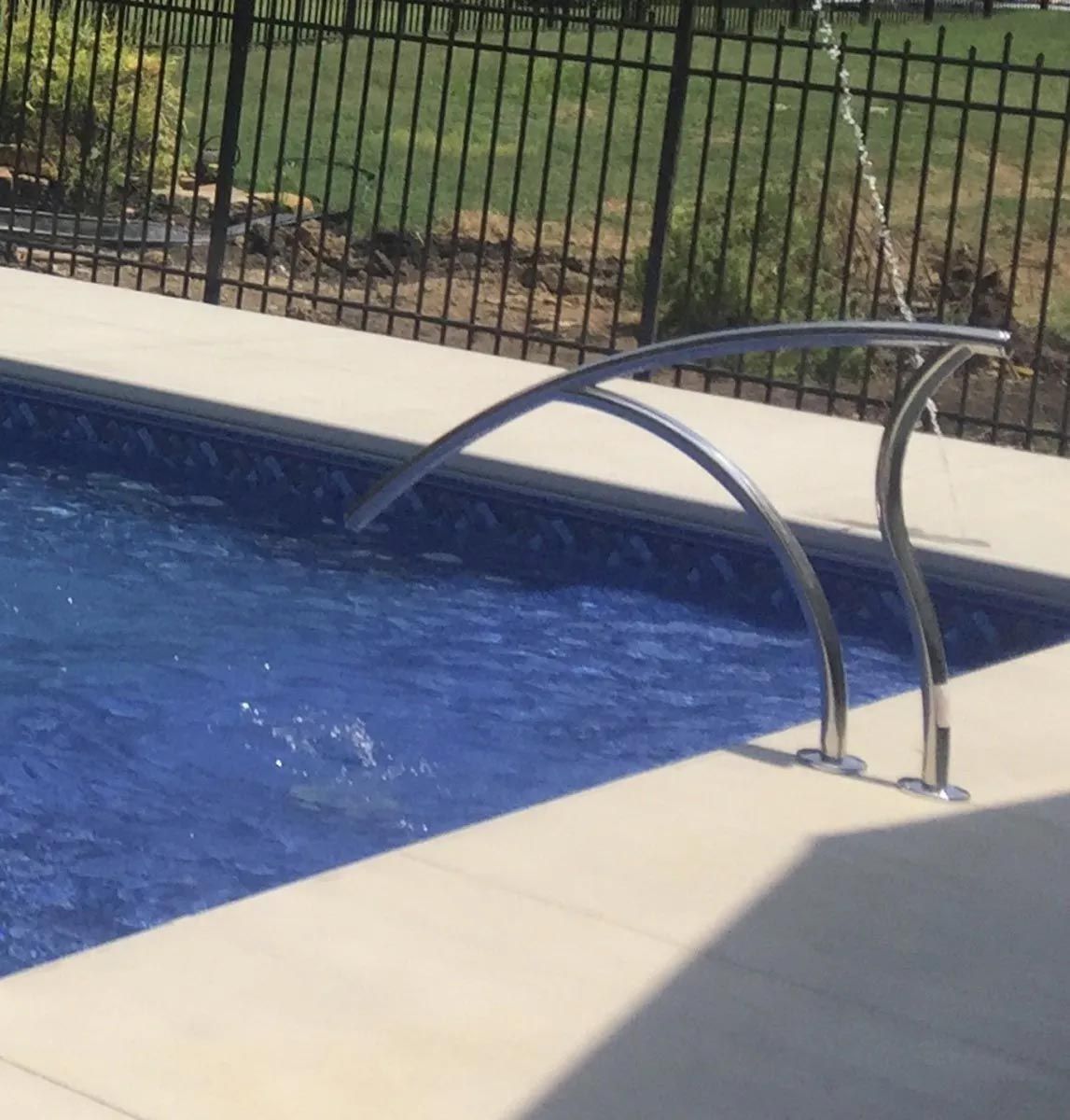 A swimming pool with a fence in the background