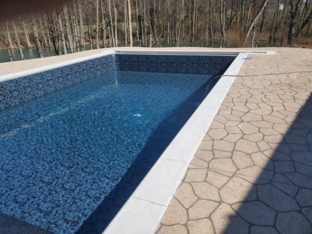 A swimming pool with blue tiles and a white border