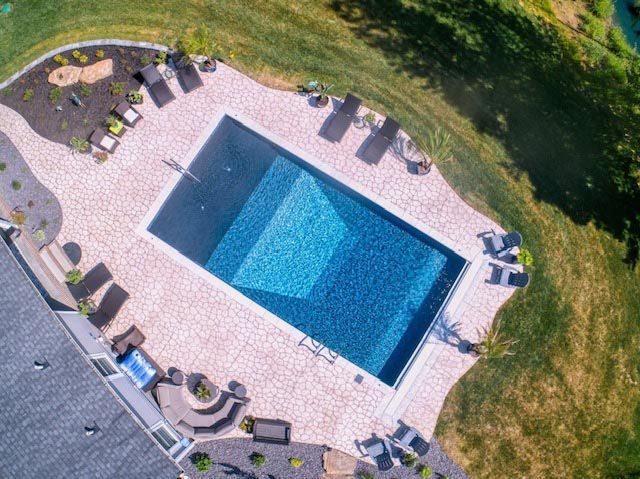 An aerial view of a large swimming pool surrounded by lawn chairs.