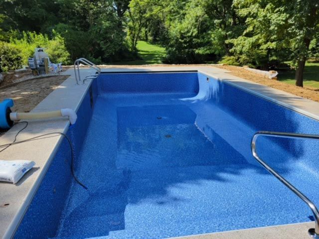 A large blue swimming pool is being built in a backyard