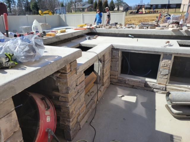 A red bbq grill is sitting in a kitchen under construction